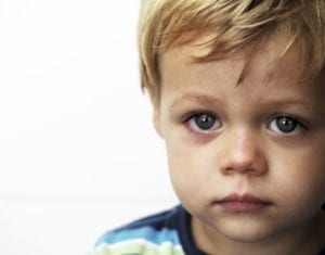 image of toddler boy who has red eyes from crying representing daycare abuse