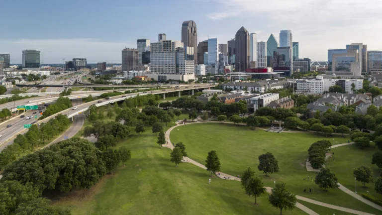 Commute transport moving along green parks on North Central Expressway to Dallas Downtown, TX.